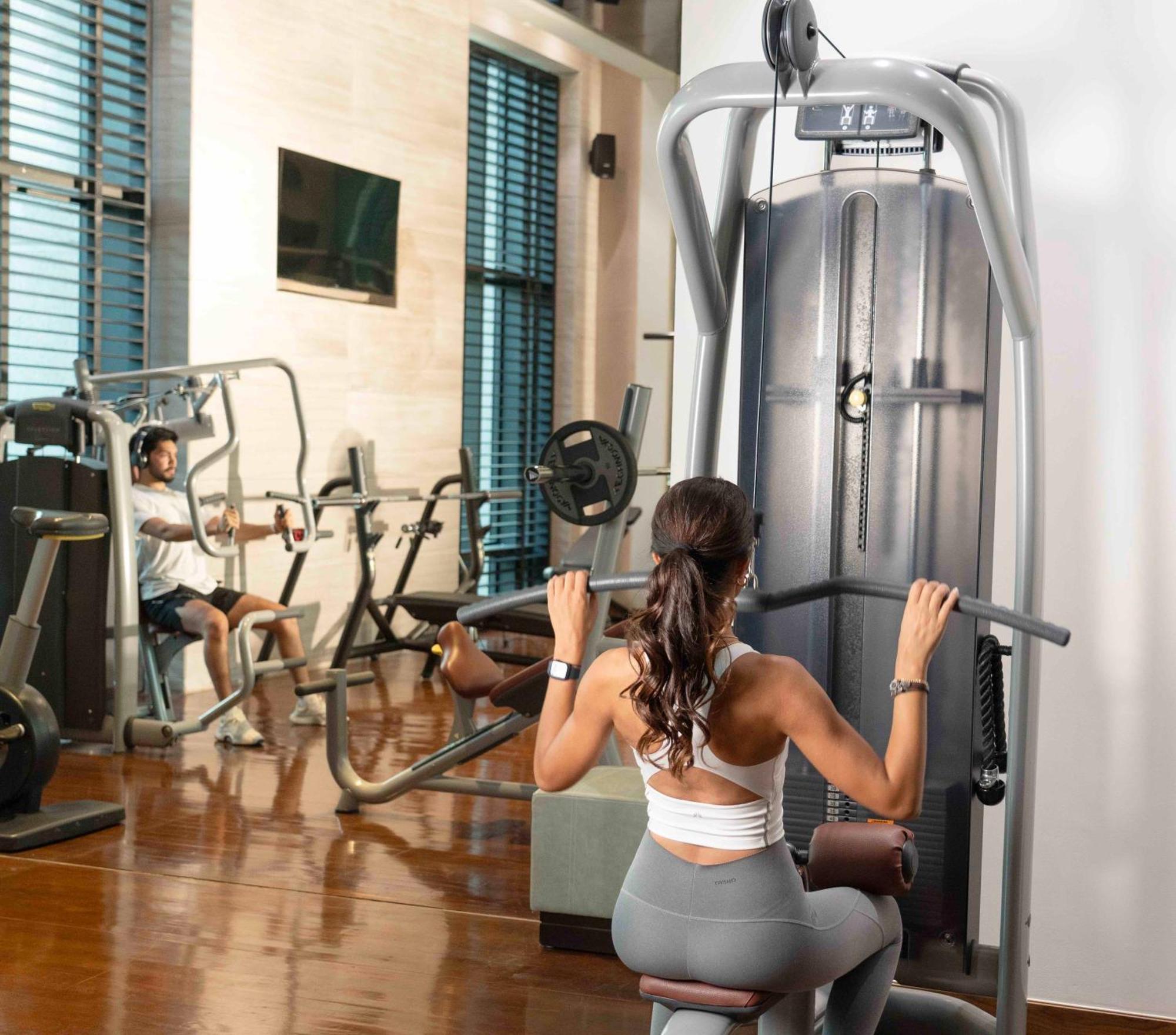 Fairmont Riyadh Bagian luar foto A woman using a lat pulldown machine